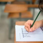 Pessoa faz prova em sala de aula durante concurso público