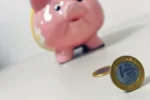 Porquinho e moeda de R$ 1