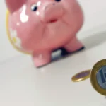 Porquinho e moeda de R$ 1